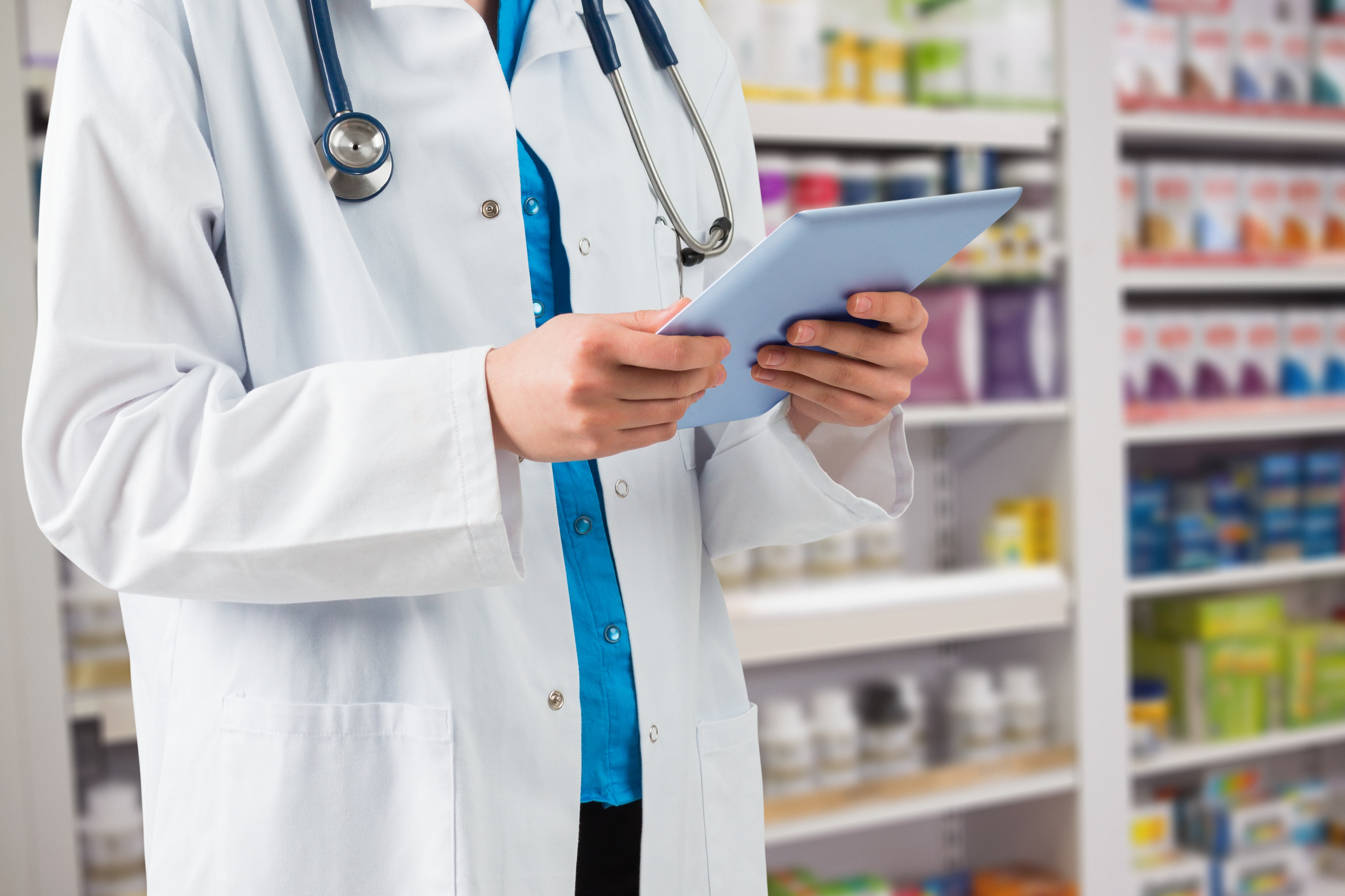 Pharmacist with tablet in modern pharmacy